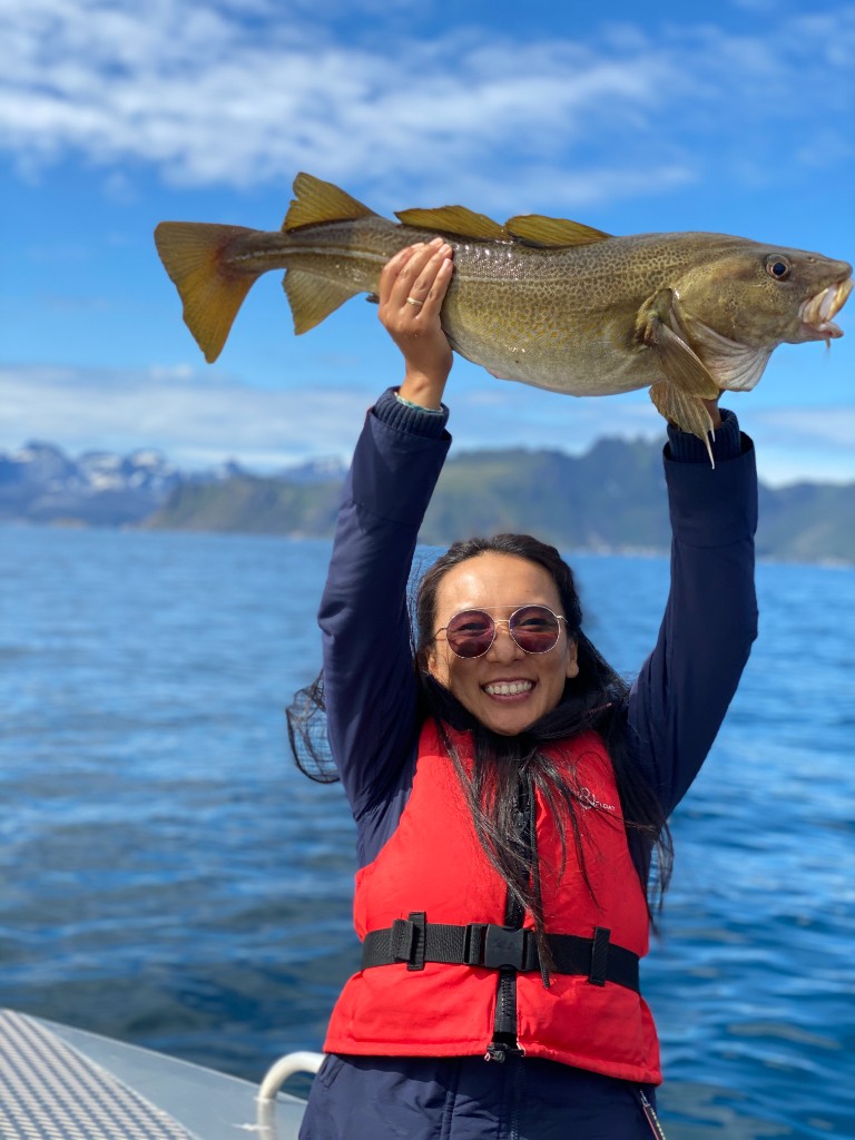 Holding a freshly caught cod on a boat in the fjords